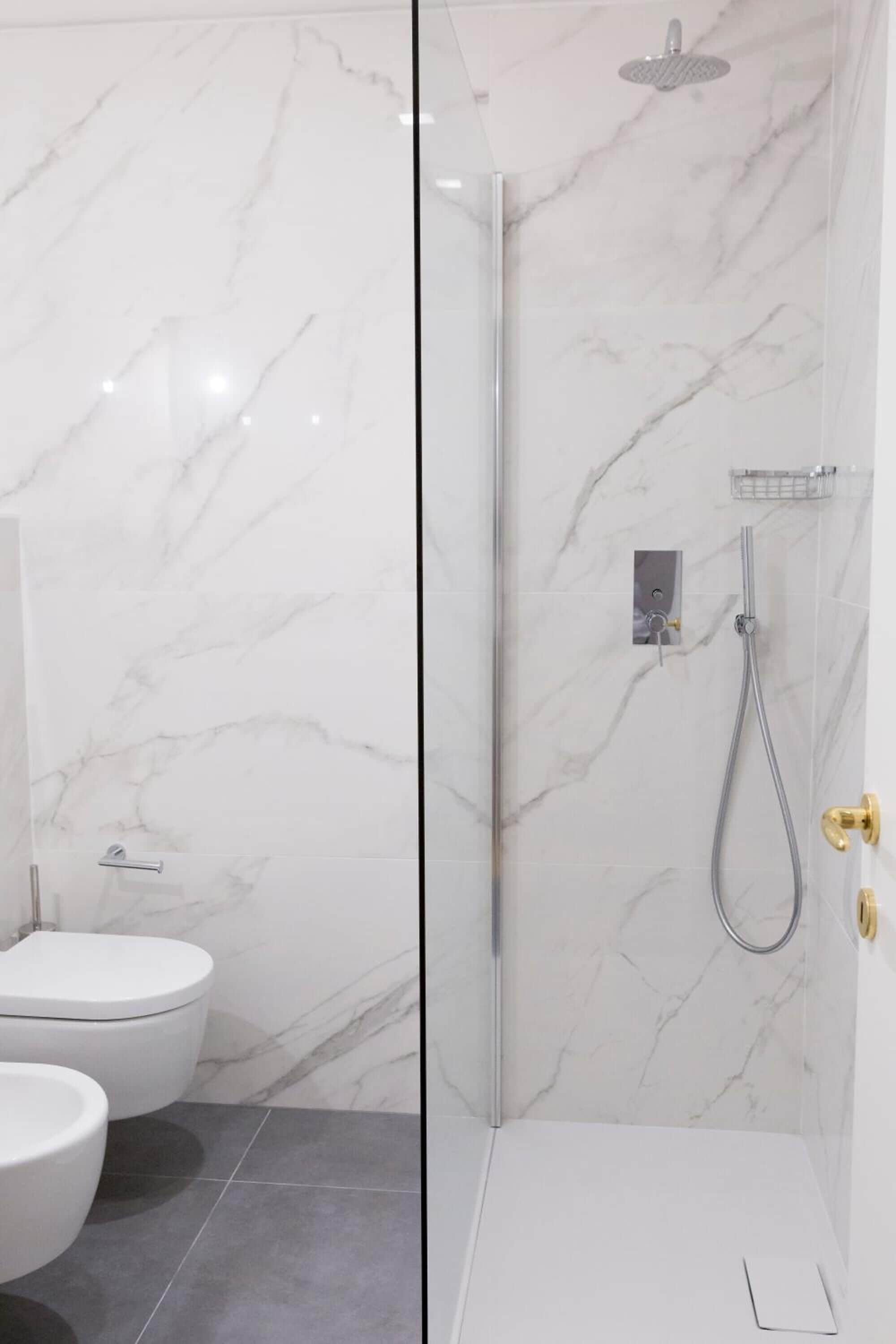 Un baño moderno con cabina de ducha de vidrio, inodoro y bidé.