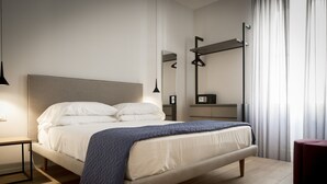 A modern bedroom with a bed, bedside tables, a mirror, and a wardrobe. - Trieste 411 e Trieste 411 II (Rooms & Apartments) (Trieste)