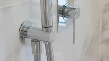 A modern shower with a handheld spray head and a wall-mounted control panel.