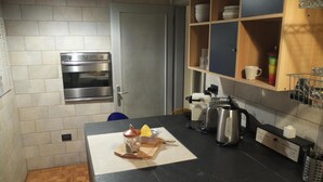 Une cuisine compacte équipée d’un four encastré, d’une machine à café et d’un grille-pain.