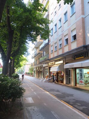 Una calle con una hilera de tiendas, incluyendo un escaparate visible con un letrero que dice "CARISMA".