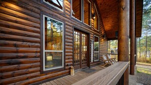 A log cabin with a wooden deck and large windows. - Bryce’s Crossroad | Family Cabin Near Broken Bow Lake (Broken Bow)
