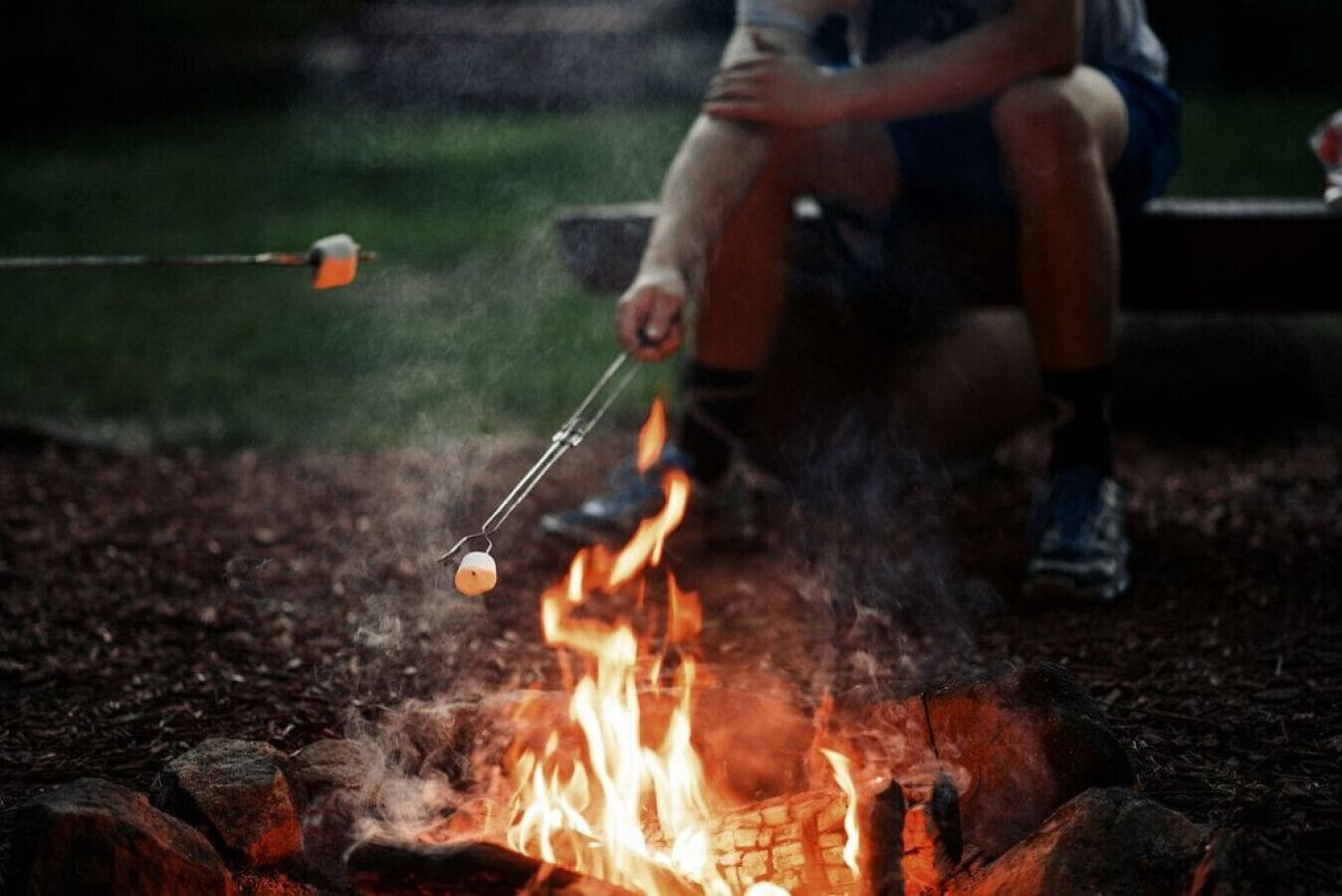 A campfire with a marshmallow being roasted.