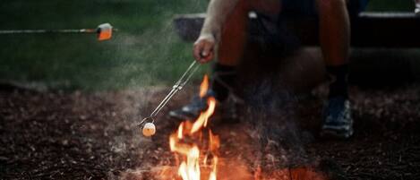 A campfire with a marshmallow being roasted.