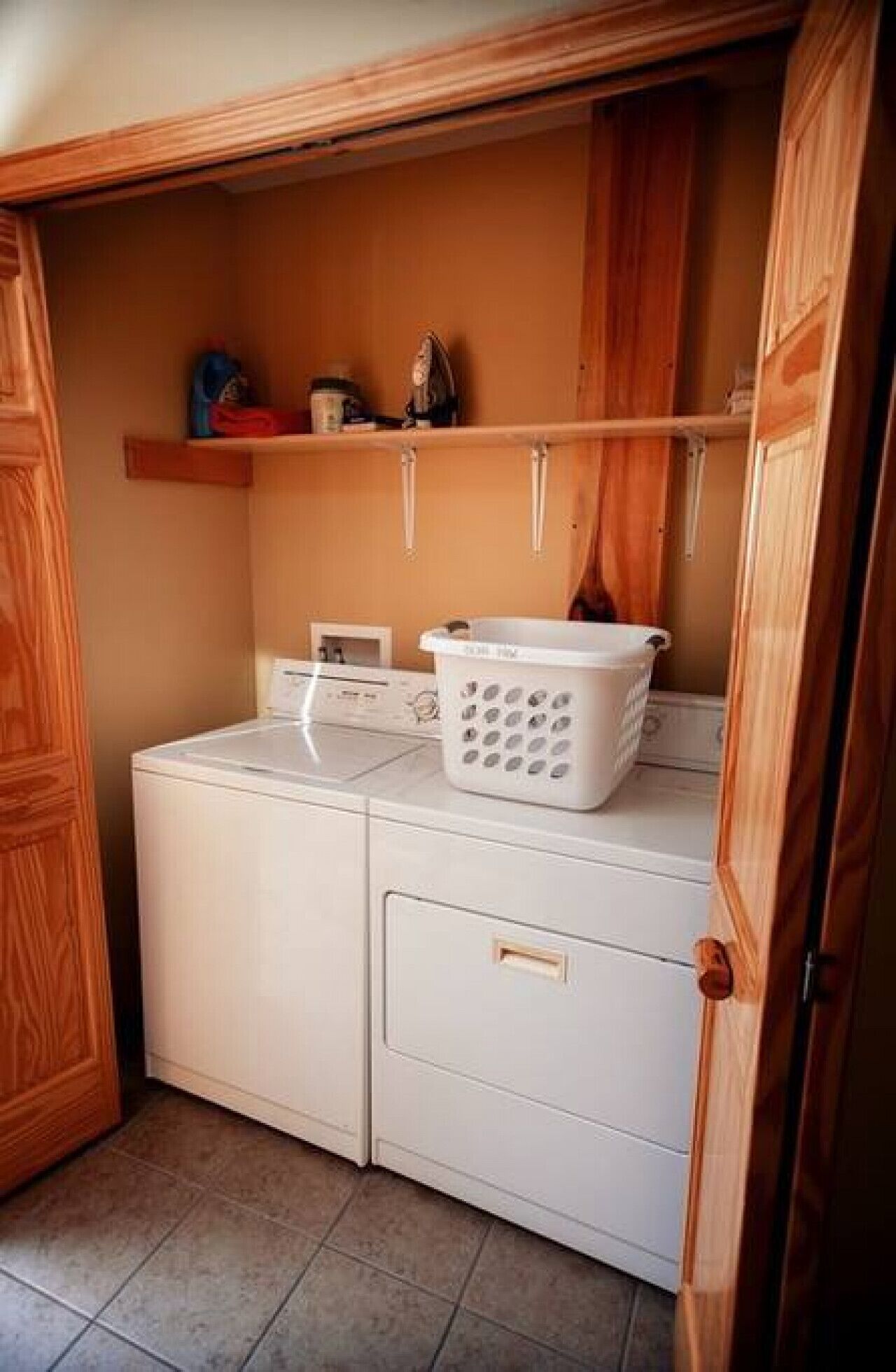 A laundry area with a washing machine and a drying rack.