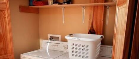 A laundry area with a washing machine and a drying rack.