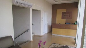 A hotel lobby with a reception desk, a staircase, and a seating area. - Hotel Capri (Medianeira)
