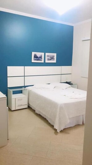A bedroom with a bed, nightstands, a dresser, and two framed pictures on the wall. - Hotel Capri (Medianeira)