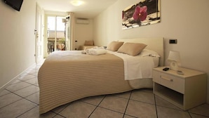 A bedroom with a bed, bedside table, and a painting on the wall. - A Casa Di Amici (Giardini Naxos)