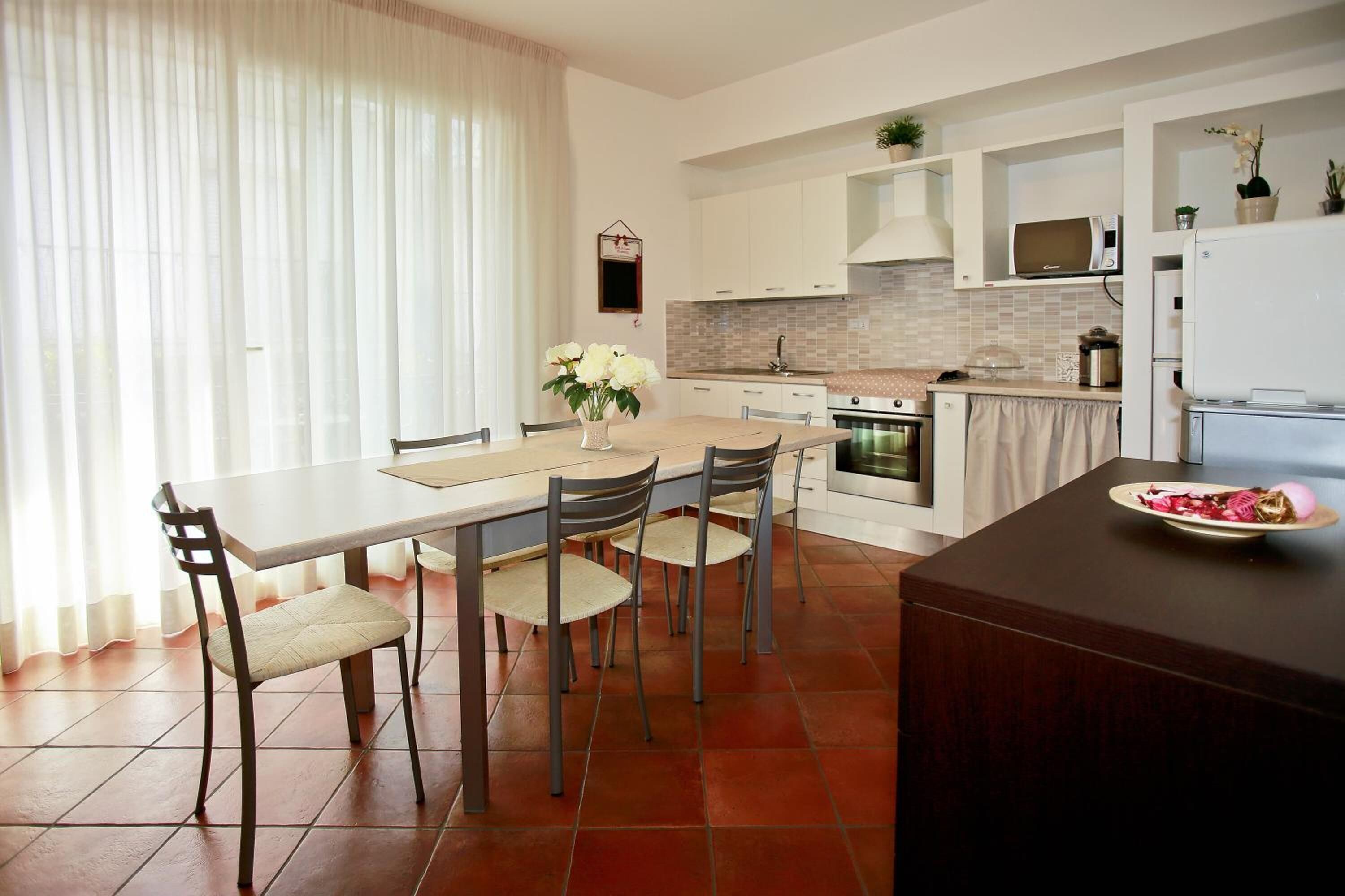 Une cuisine moderne avec une table à manger, des chaises et un réfrigérateur.