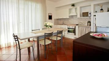 Una cocina moderna con una mesa de comedor, sillas y un refrigerador.