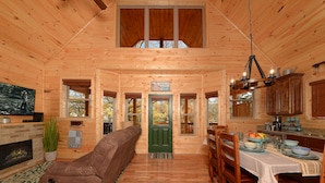 Un intérieur de chalet chaleureux comprenant un espace de vie, un coin repas et une cuisine.