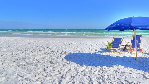 A beach with a blue umbrella and two beach chairs. - Short Walk to Beach • Pool • Pets Allowed • (Miramar Beach)