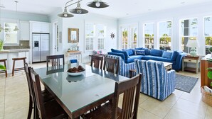 Una cocina amplia con zona de comedor, un sofá azul y un ventanal grande.