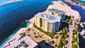 Ett flygbildsbild av ett hotell vid kusten med en huvudbyggnad, en strand och en brygga.