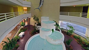 En atrium med flera våningsplan, med en central fontän och en dekorativ fiskstaty.