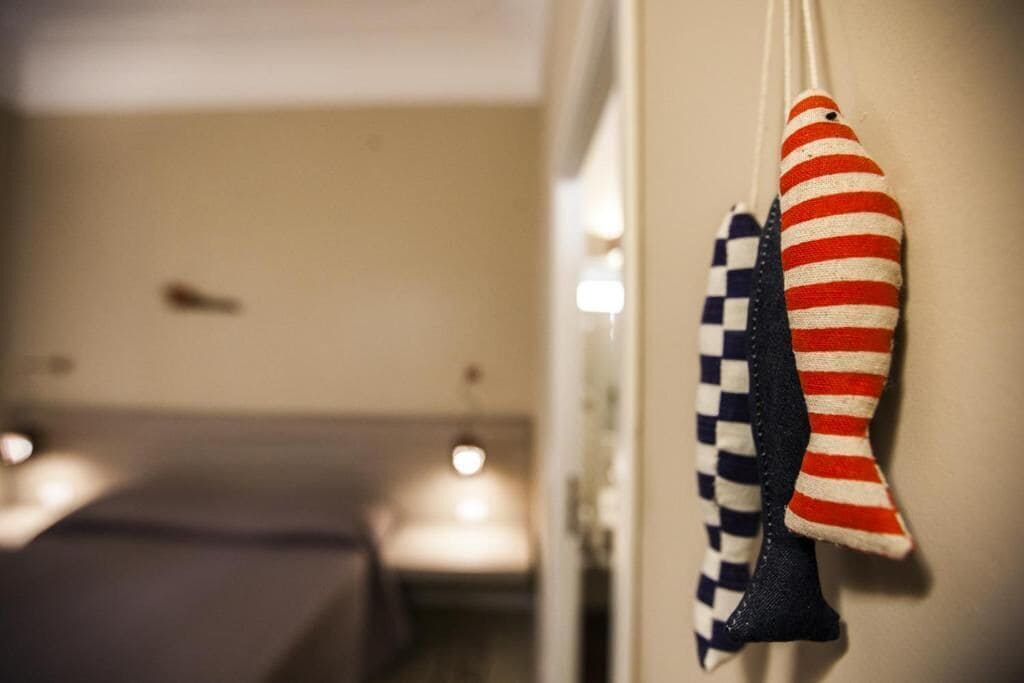 Un corridoio con un letto e una decorazione a forma di pesce appesa al muro.
