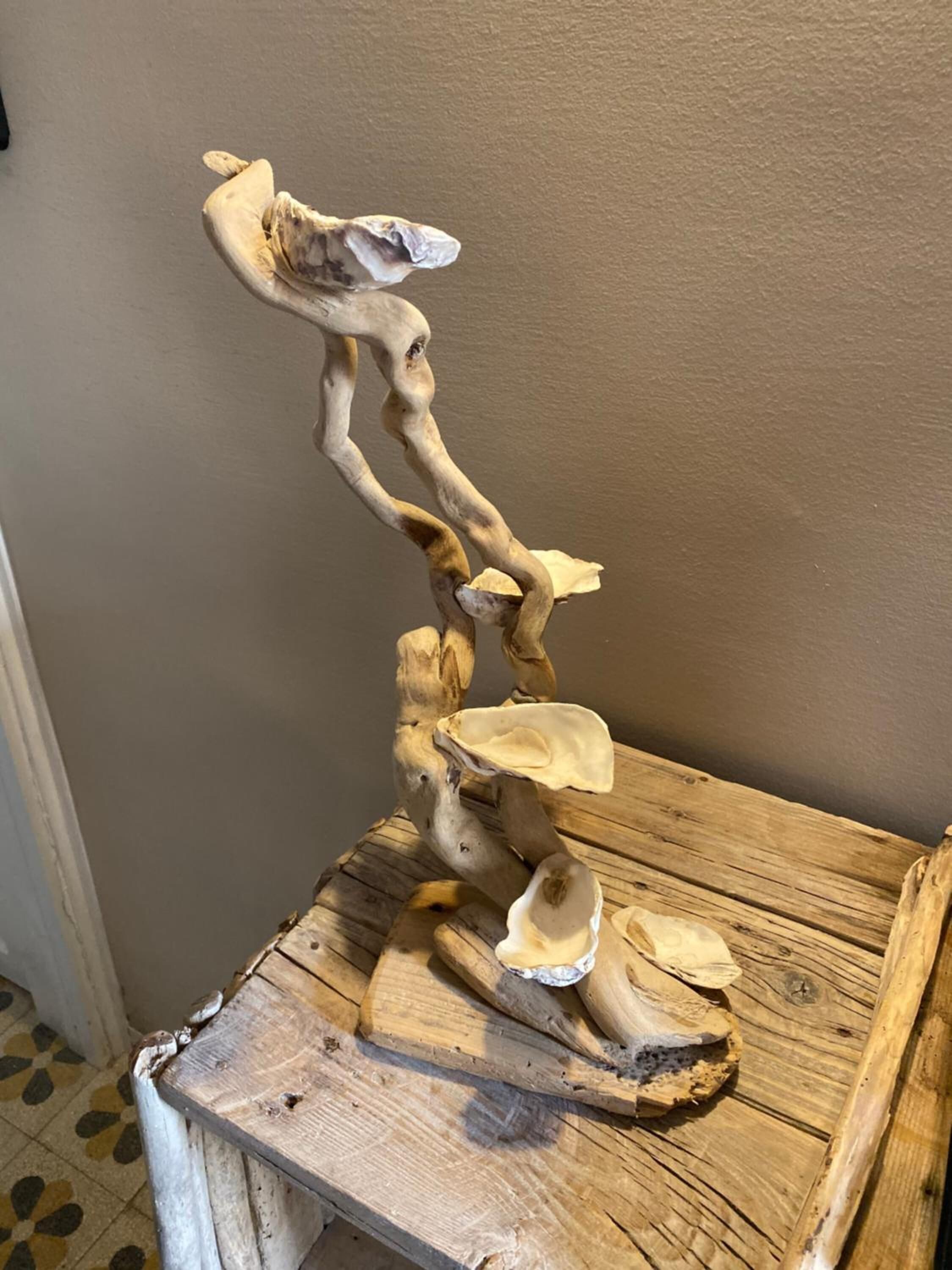 A wooden table with a unique, abstract sculpture.