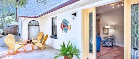 A house with a covered patio, outdoor seating, and a large window with a decorative fish mural.