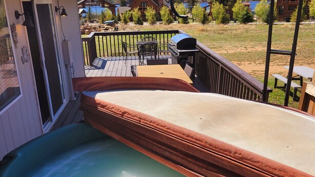 A hot tub on a deck with a mountain view in the background. - Charming 2 Bedroom w/ Private Hot Tub and Mountain views! (Estes Park)