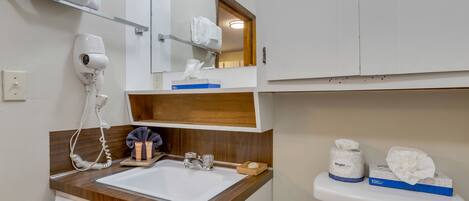 A bathroom with a sink, mirror, towel rack, and toilet.