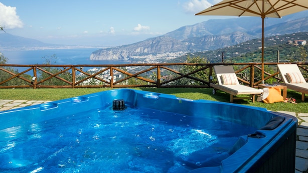 Ein Whirlpool mit freiem Blick auf das Meer und die Berge.