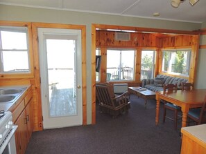 A cabin interior with a kitchen, dining area, and seating space.