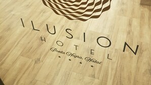 Logotip amb un dibuix concèntric i el text 'ILUSION HOTEL' juntament amb 'Ponta Negra, Natal'.