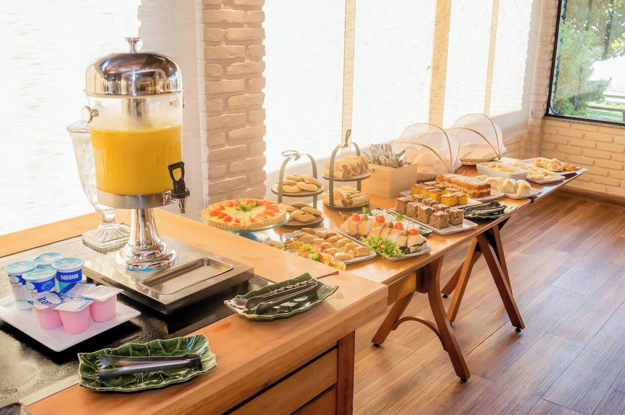 Ein Buffet mit Saftspender, verschiedenen Speisen und Blick aus dem Fenster.