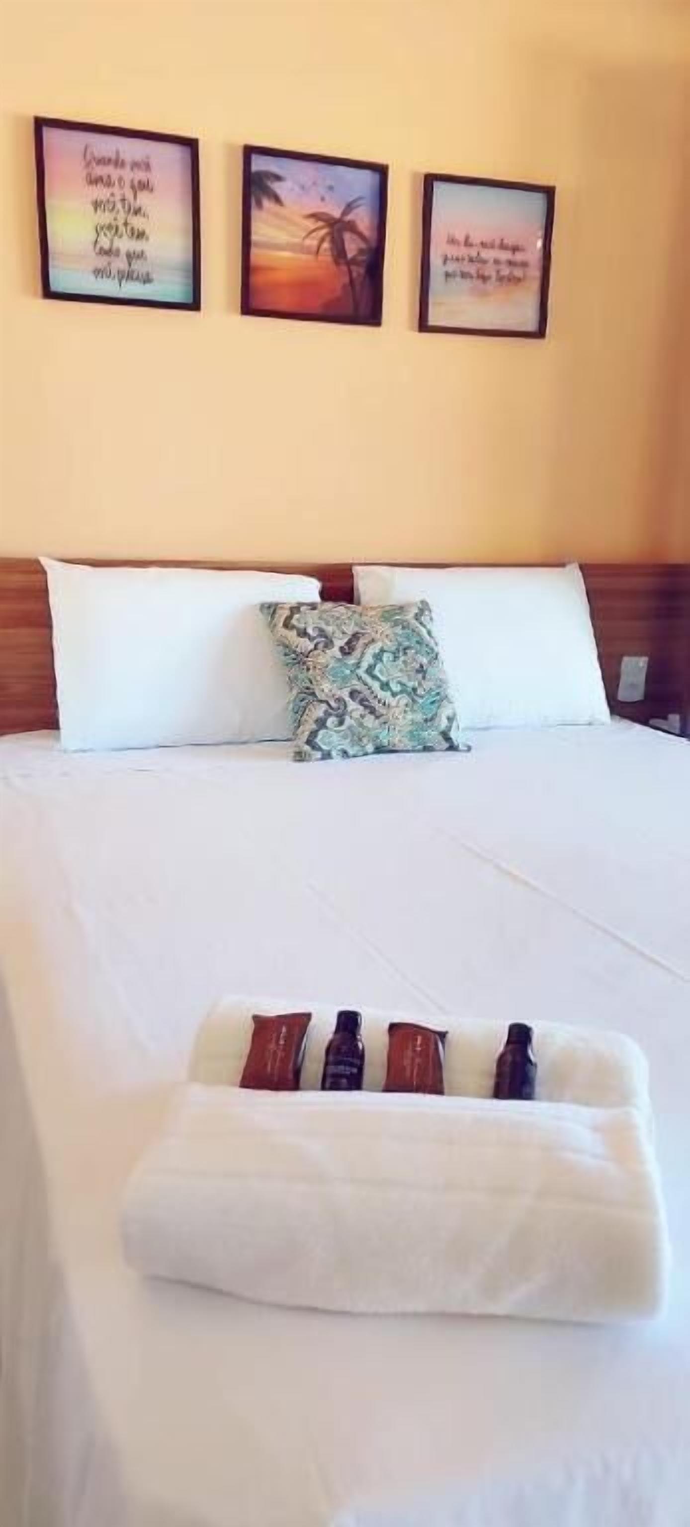 Habitación de hotel con cama, almohadas y bandeja con artículos de aseo.