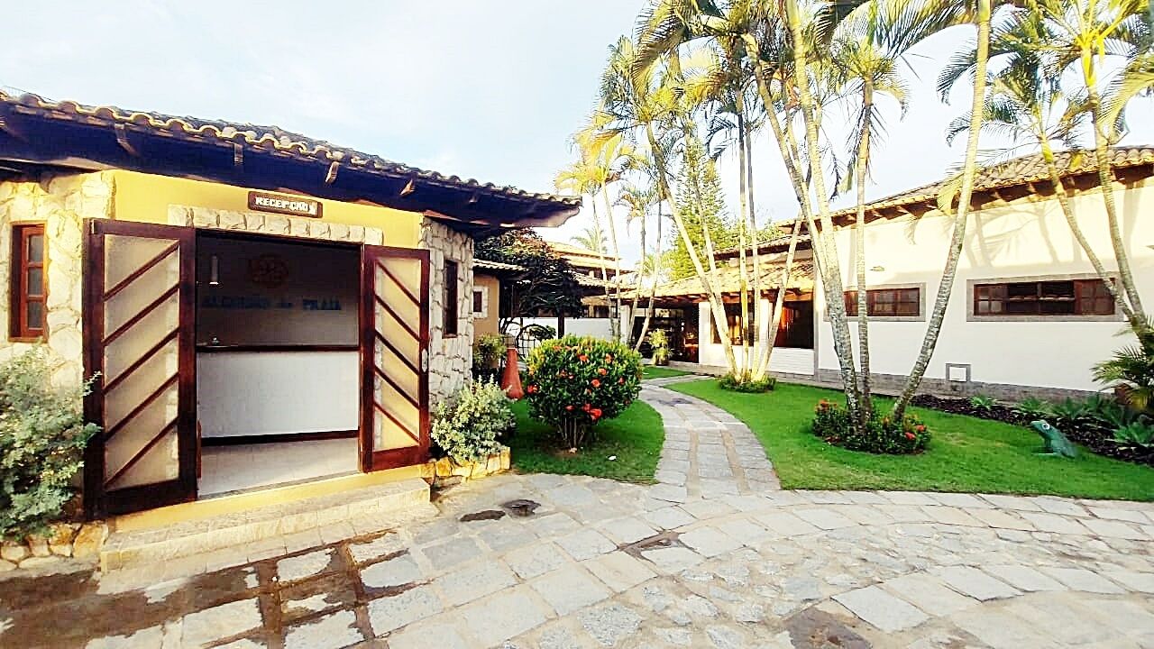 Un patio con zona de recepción, sendero de piedra y palmeras.