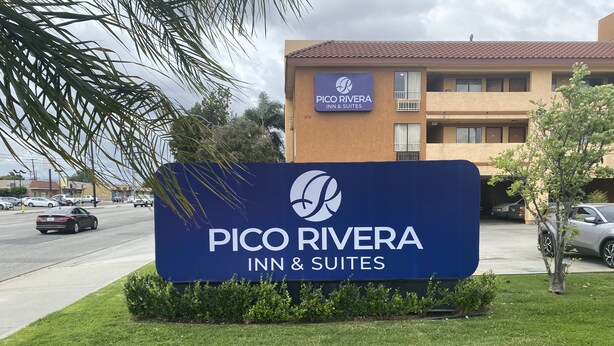 Schild für das Pico Rivera Inn & Suites, im Hintergrund ist das Gebäude deutlich zu sehen.