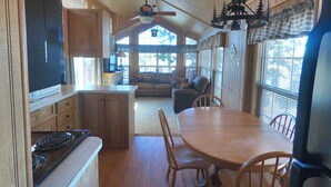 A wooden cabin interior with a kitchen, dining area, and living room. - Pope's Landing Marina (Alba)
