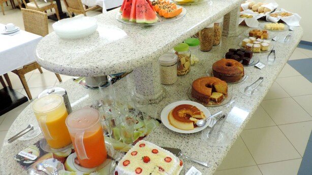 A buffet with various food items and drinks, including watermelon, melon, and a variety of desserts. - Hotel Pequeno Mundo II (Campo Verde)