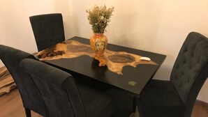 Ein Esstisch mit einer einzigartigen Holzplatte, umgeben von zwei gepolsterten Stühlen.