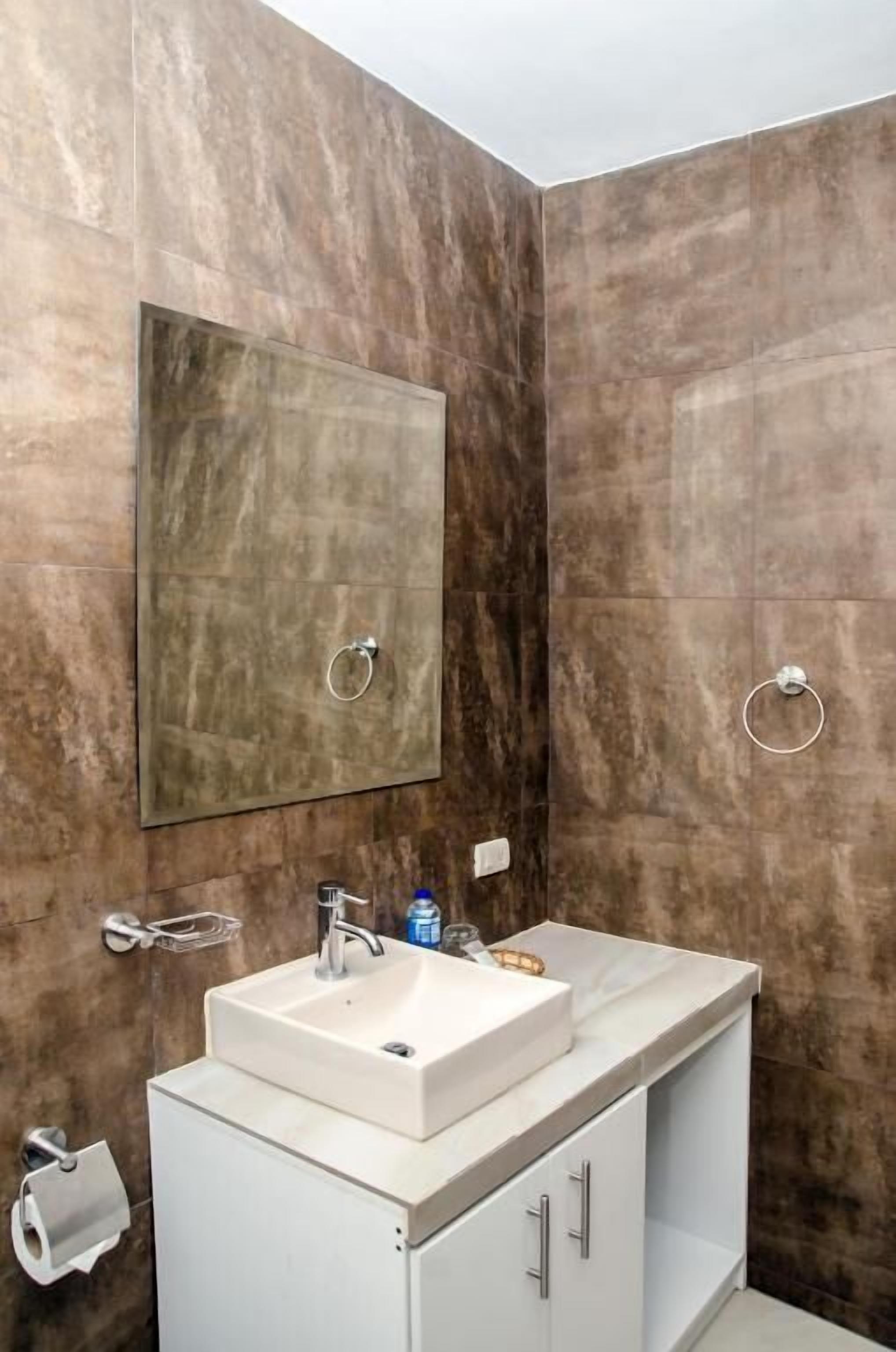 Een badkamer met een grote spiegel, een wastafel en een toilet.