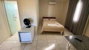 A hotel room with a bed, a desk, a chair, a wardrobe, and a window with curtains. - Hotel Londe (Patrocinio)