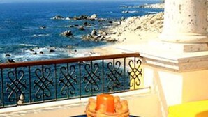 Un balcón con vistas despejadas al mar y a la costa rocosa.