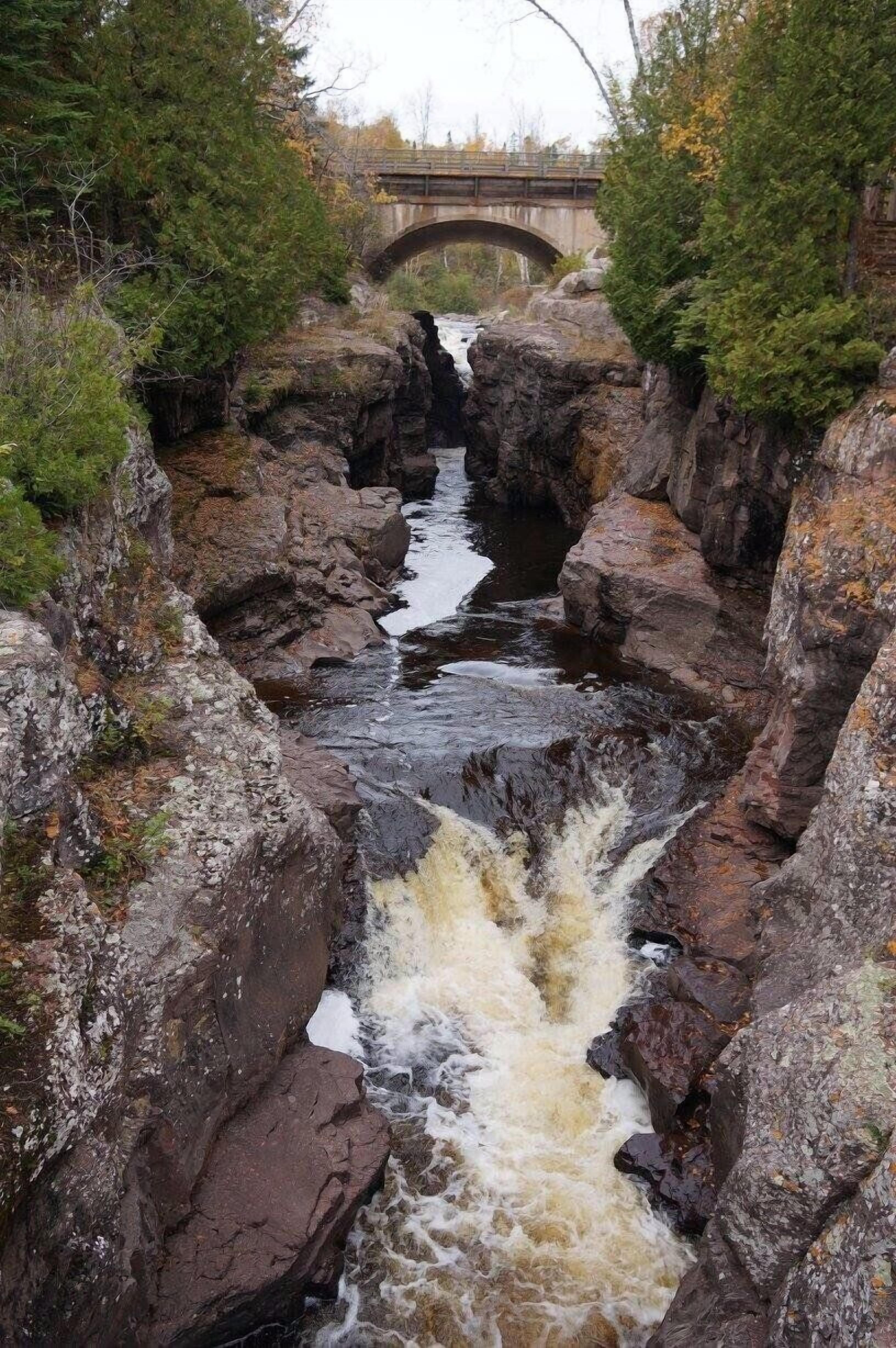 Kivinen joki, jonka yllä on silta ja taustalla näkyy maisema.