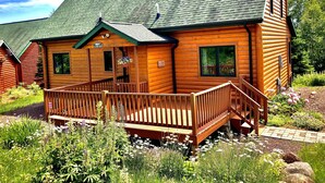A log cabin with a porch and a small garden area. - Lutsen Log Lodge! Ski, Hike, Golf & Bike (Lutsen)