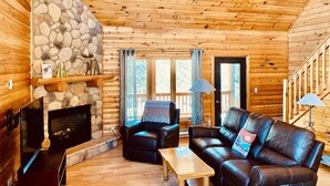 A cozy cabin interior with a stone fireplace, leather sofas, wooden floors, and a wooden ceiling. - Lutsen Log Lodge! Ski, Hike, Golf & Bike (Lutsen)