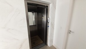 An elevator with a control panel, a door, and a marble wall. - 224, Great apartment a few meters from the beach (Bombas)