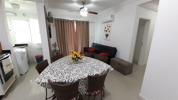 A dining area with a table set for four, surrounded by wicker chairs. A ceiling fan is visible above the table. - 224, Great apartment a few meters from the beach (Bombas)