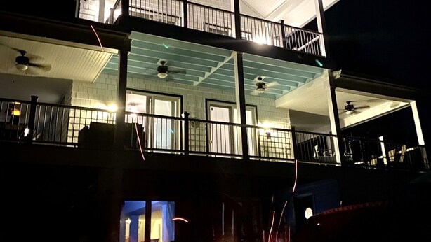 Un edificio de dos pisos con un balcón y una chimenea en primer plano.