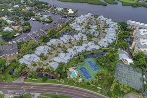 Vista aérea de una zona residencial con casas, una cancha de tenis y una piscina.