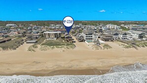 A coastal residential area with beachfront properties, a beach, and a marker for Village Realty.