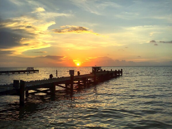 A pier extending into calm waters with a sunset in the background. - Las Amapolas by the sea. King Bed + A/C (1B) (San Pedro)