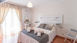 A modern bedroom with a bed, bedside table, mirror, and a chair. - Villa Claudia Nerja by Ruralidays (Málaga)