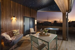 Relax in the serene outdoor seating area with a starry night sky above, a comfortable bench, and a table for a peaceful evening.