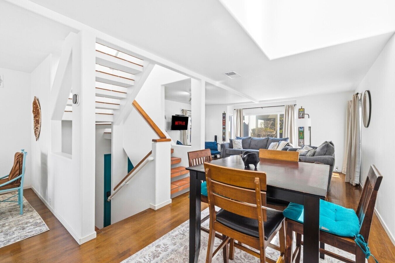 Un interior moderno con comedor, escalera y sala de estar.